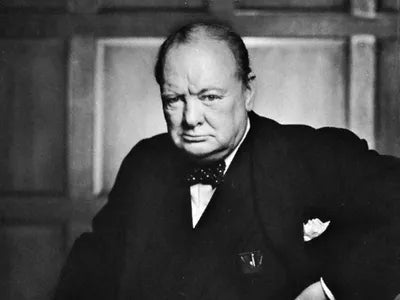 Black and white portrait of Winston Churchill in formal attire with a serious expression.